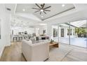 Spacious living area with wood floors, neutral decor, lots of light, and views of the kitchen and the outdoor patio at 6314 Soratrace St, Lithia, FL 33547