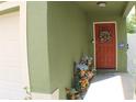 Welcoming front entrance with a decorated door and colorful potted plants at 716 Burlwood St, Brandon, FL 33511