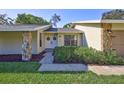 Inviting entryway showcases double doors, rock accents, lush landscaping, and a well manicured lawn at 864 Pinewood W Ter, Palm Harbor, FL 34683