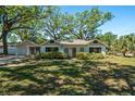 Charming single-story home featuring a well-manicured lawn, lush landscaping, and mature trees providing ample shade at 203 S Coolidge Ave, Tampa, FL 33609