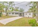 Charming single-story home features a well-maintained lawn and a long driveway leading to a carport at 2412 53Rd S St, Gulfport, FL 33707