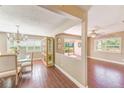 Open-concept dining room featuring elegant chandelier, wood-look floors, and plenty of natural light at 2507 Royal Pines Cir # 2H, Clearwater, FL 33763