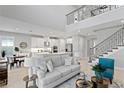 Bright and airy living room with high ceilings, a modern staircase, and an open floor plan at 2612 Leafwing Ct, Palm Harbor, FL 34683