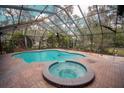Relaxing pool area with hot tub, surrounded by a screened enclosure at 2910 Pine Club Dr, Plant City, FL 33566