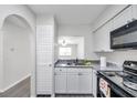 Bright kitchen featuring white cabinetry, stylish countertops, and modern appliances at 3147 Mission Grove Dr # 3147, Palm Harbor, FL 34684