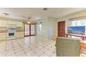Bright kitchen with white appliances and tile flooring, leading to outdoor access at 412 River S Blvd, Nokomis, FL 34275