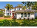 Elegant two-story home featuring a red front door, decorative windows, and a well-manicured lawn at 4605 W Vasconia St, Tampa, FL 33629