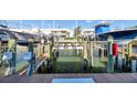 Modern boat lift system on the water with view of condominiums in the background at 5101 Coquina Key Se Dr # A, St Petersburg, FL 33705