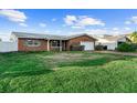 Charming brick home with a well-maintained front yard, a driveway and an attached garage at 720 Capri Blvd, Treasure Island, FL 33706