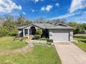 Charming single-story home with a lush front lawn, flower beds, and a two-car garage at 8437 Indies Dr, Hudson, FL 34667