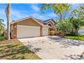 Exterior angle of home showing 3 car garage and large driveway with palm trees in yard at 8746 Tantallon Cir, Tampa, FL 33647