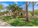 View of the front yard featuring professional landscaping, including various plants and large shade trees at 8746 Tantallon Cir, Tampa, FL 33647