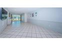 Bright living room featuring white tile flooring and sliding glass doors at 9214 Mission Oaks Blvd, Seminole, FL 33776