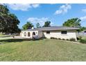 Beige single-story home with arched gated entry and a well-manicured front lawn at 1006 Mandalay Dr, Brandon, FL 33511
