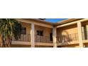Beige exterior features decorative railings and balconies with a palm tree in the foreground at 10351 Regal Dr # 18, Largo, FL 33774