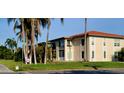 Well-maintained condo building with lush lawn, tropical palms, and balconies on the second story at 10351 Regal Dr # 18, Largo, FL 33774