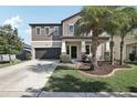 Beautiful home showcasing a manicured front yard, covered entrance, and convenient two-car garage at 11056 Little Blue Heron Dr, Riverview, FL 33579