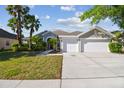 Charming single-story home featuring a three car garage, large driveway, and lush landscaping at 12304 Silton Peace Dr, Riverview, FL 33579