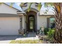 Inviting front entrance featuring a decorative door, stone accents, and colorful potted plants at 14205 Stockwell Ln, Ruskin, FL 33573