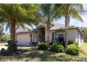 Inviting single-story home with lush landscaping and a two-car garage, creating a welcoming curb appeal at 14205 Stockwell Ln, Ruskin, FL 33573