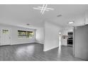 Bright living room with modern lighting, gray wood floors, and large windows at 2070 62Nd S Ave, St Petersburg, FL 33712