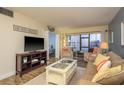Cozy living room with a comfortable couch, view to a sunroom, and beach house themed decorations at 2211 Belleair Rd # D12, Clearwater, FL 33764
