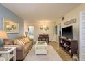 Comfortable living room featuring beach decor, a plush sofa, and a flat-screen TV for relaxation at 2211 Belleair Rd # D12, Clearwater, FL 33764