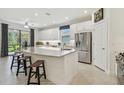 Bright kitchen featuring an island with seating, stainless steel appliances, and stylish countertops at 29488 Ginnetto Dr, Wesley Chapel, FL 33543