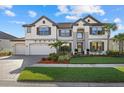 Elegant two-story home featuring a three-car garage, beautiful landscaping, and a tile roof at 33105 Kateland Dr, Wesley Chapel, FL 33545