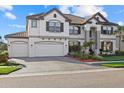 Attractive two-story home showcasing a brick driveway, tropical landscaping and an attached two-car garage at 33105 Kateland Dr, Wesley Chapel, FL 33545