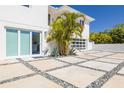 Modern home showcasing its beautiful entryway, pavers, and lush tropical landscaping at 3418 Overlook Ne Dr, St Petersburg, FL 33703