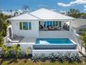 Stunning modern home featuring a beautiful pool, outdoor lounge area, and lush landscaping at 3418 Overlook Ne Dr, St Petersburg, FL 33703