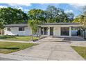 Well-lit single-story home with a covered carport, concrete driveway, and manicured front yard at 4105 W Iowa Ave, Tampa, FL 33616