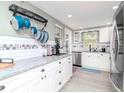 Bright, updated kitchen with white cabinets, stainless steel appliances, and a hanging pot rack at 5433 Palmetto Rd, New Port Richey, FL 34652
