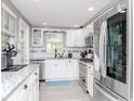 Modern kitchen with white cabinetry, stainless steel appliances, and a stylish backsplash at 5433 Palmetto Rd, New Port Richey, FL 34652