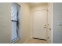 Bright hallway with neutral walls, tile flooring, and a window providing natural light at 720 Lyndhurst St # 1121, Dunedin, FL 34698