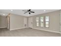 Bright living room with large windows, neutral walls, and stylish ceiling fan at 7323 Andre Dr, Zephyrhills, FL 33541