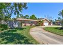 Landscaped yard and long driveway leading to this tan home with a two-car garage at 8243 37Th N Ave, St Petersburg, FL 33710