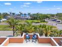 Relaxing balcony view featuring comfortable chairs, vibrant palm trees, and scenic water views beyond at 920 N Shore Ne Dr, St Petersburg, FL 33701