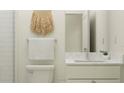 Well-lit bathroom with white vanity, modern fixtures, toilet, and decor at 9308 Gladsome Dr, Land O Lakes, FL 34637