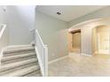 Bright and open foyer with tile flooring, staircase, and view of the hallway at 9917 Ivory Dr, Ruskin, FL 33573
