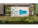 Aerial view of a community pool and tennis court surrounded by well-manicured landscaping and mature trees at 10034 64Th N Ave # 14, St Petersburg, FL 33708