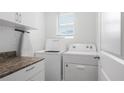 A well-lit laundry room featuring modern appliances, storage cabinets, and countertop space at 10914 Penny Gale Loop, San Antonio, FL 33576