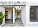 Covered walkway to home's entrance, featuring house numbers, window, and decorative plants at 11440 Harbor Way # 5009, Largo, FL 33774