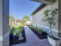 Charming covered front porch with brick pavers and manicured landscaping at 120 Moscata Way, Nokomis, FL 34275