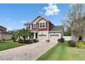 Charming two-story home with a well-manicured lawn, brick driveway, and inviting curb appeal at 12328 Streambed Dr, Riverview, FL 33579