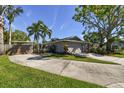 Wide driveway leading to a two-car garage and carport, complemented by mature landscaping and trees at 143 58Th S Ave, St Petersburg, FL 33705