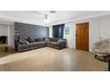 Comfortable living room featuring a gray sectional sofa and distinctive brick accent wall at 1988 58Th N St, St Petersburg, FL 33710