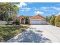 Charming single-story home boasts a three-car garage and manicured landscaping in a suburban neighborhood at 2302 Azalea Dr, Palm Harbor, FL 34683