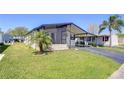 Charming single-story home featuring a covered porch, extended driveway and lush landscaping at 3051 Shady Creek Dr, Wesley Chapel, FL 33543
